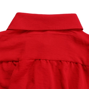 Detail of red cotton-linen shirt featuring a lapel collar and pleated yoke texture