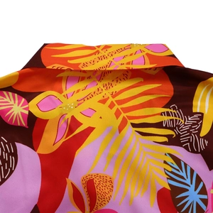 Gros plan détaillé du motif tropical vibrant et du col sur la chemise d'été