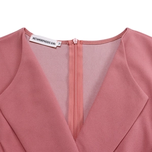 Détail du col en V avec fermeture éclair invisible et étiquette sur robe rose poudré