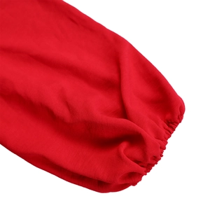 Detail view of red high waist jumpsuit featuring elasticated cuffs and textured fabric