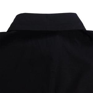 Close-up of the black turnover collar and fine twill fabric texture on the shirt