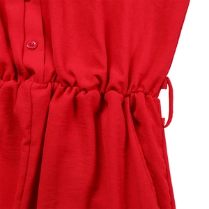 Detailed close-up of red high-waisted jumpsuit showing elastic waist and button detail