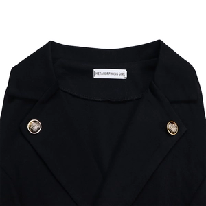 Close-up of black suit collar with gold lion head buttons and woven brand label
