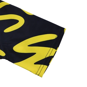 Close-up of double-needle hem on short sleeve with yellow abstract print on black fabric