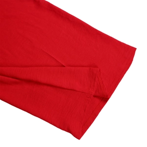 Detail of red knit jumpsuit featuring precise double-needle stitching and fabric texture