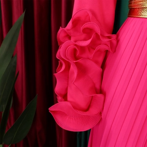 Détail de la combinaison fuchsia avec manches à volants et ceinture en métal doré