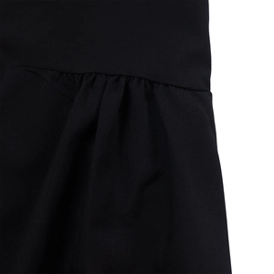 Detailed close-up of pleated black cotton fabric and fine stitching on a loose maxi dress