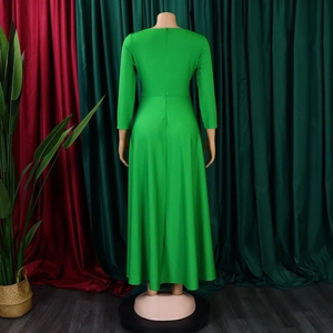 Detail view of emerald green long-sleeve maxi dress with cinched waist and pleated large hem