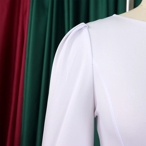 Detail view of white dress with structured puff sleeves and fine mesh textured fabric