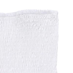 Détail du tissu blanc smocké élastique et bords à volants délicats de l'ensemble deux pièces
