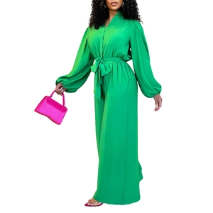 Detail of bright green long sleeve jumpsuit featuring waist drawstring and wide leg cut