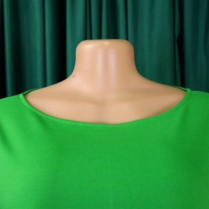 Close-up of the boat neck and textured green fabric on this elegant maxi dress