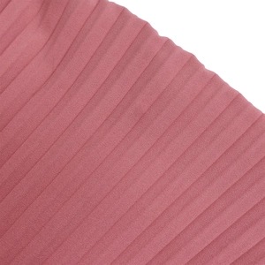 Détail du tissu plissé rose poudré avec des plis verticaux de haute qualité sur la robe