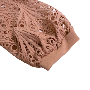 Detailed macro view of the intricate lace embroidery and elastic cuffs on dusty rose dress