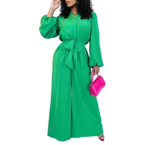 Detail of green long sleeve satin jumpsuit with shirt collar and waist tie belt
