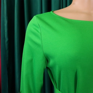 Detail view of grass green dress showing high-quality round neck and smooth shoulder seams