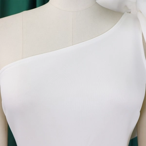 Detail of white one-shoulder evening gown featuring precise stitching and premium fabric
