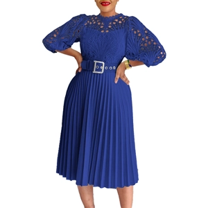 Detail of blue lace embroidery on long sleeve dress with pleated skirt and wide waist belt