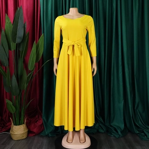 Detailed close-up of bright yellow long-sleeved dress with waist tie and A-line skirt