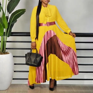 Detail of elegant pleated color-block hem and purple waistband on a long-sleeve midi dress