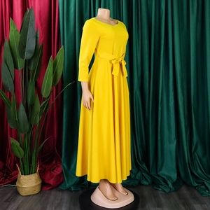 Detail of yellow long sleeve maxi dress featuring a matching waist tie and A-line silhouette