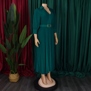 Detailed view of dark green pleated maxi dress with elegant V-neck and golden buckle belt