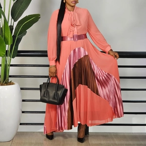 Detail of coral pink pleated dress with color-block hem and waist belt tie neck design