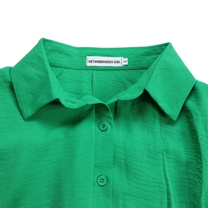 Detail of green cotton linen shirt collar with textured fabric and resin buttons