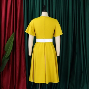 Detail of elegant yellow plus size dress featuring flared sleeves and a white waist belt