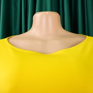 Detail of crew neckline on a vibrant yellow dress with high-quality reinforced stitching