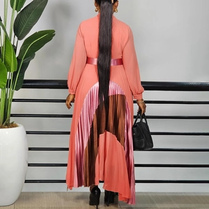 Rear view of pleated long sleeve dress with coral and brown patchwork skirt and waist belt