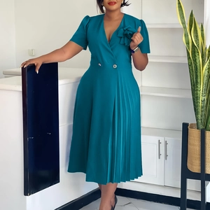 Detail showing the elegant peacock blue V-neck dress with pleated hem and floral design