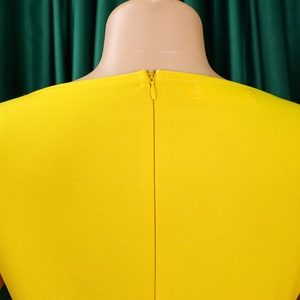 Close-up of bright yellow dress featuring a matching invisible zipper on the back seam