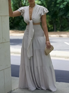 Ensemble deux pièces beige avec haut court à nouer col V et jupe longue plissée taille haute