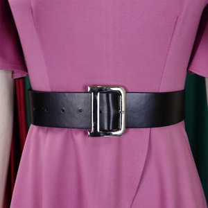 Detail eines breiten schwarzen Gürtels mit einer großen silbernen D-Metallschließe am Kleid