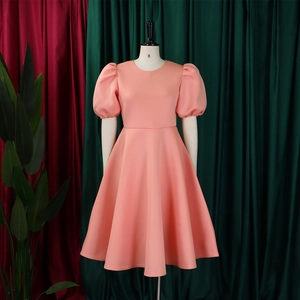 Détail des manches bouffantes rose corail et silhouette trapèze sur un mannequin