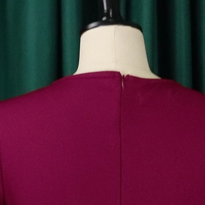 Detail view of invisible zipper closure on the back of wine red elegant V-neck dress