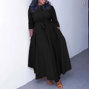 Detail of a black long-sleeve maxi dress with an elegant waist tie and flowing hemline