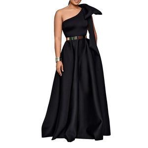 Detail of elegant black one-shoulder evening gown with large bow and gold waist belt