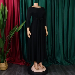 Detail of elegant black maxi dress featuring a round neck, 3/4 sleeves and a bow waist tie
