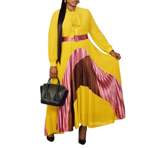 Detailed view of color-block pleated hem and bow neckline on long-sleeved dress