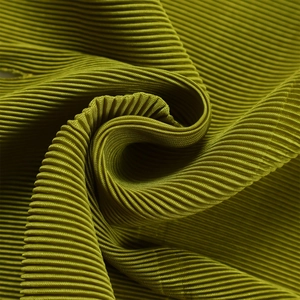 Dettaglio del tessuto plissettato verde con sottili pieghe a fisarmonica e texture