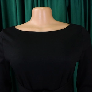 Detail of elegant black off-shoulder neckline and soft elastic fabric on a fashion dress