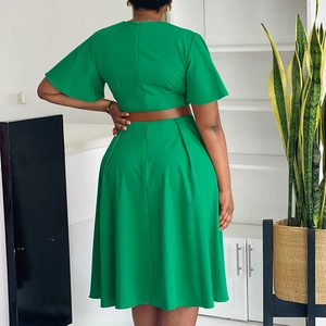 Back view of elegant emerald green V-neck dress with brown leather belt and pleated hem