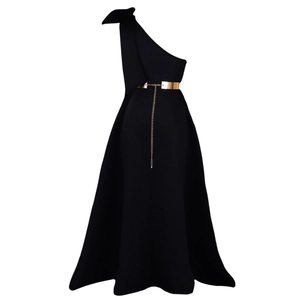 Detail of elegant black one-shoulder dress with bow accent and golden metal waist chain