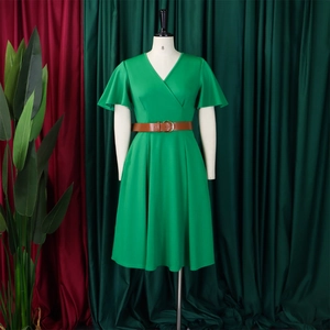 Detail of green V-neck dress with brown belt and golden buckle on a mannequin