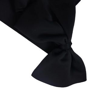 Detail shot of the elegant black bow-knot shoulder and ruched fabric texture on this dress