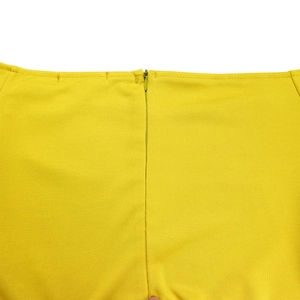 Détail d'une combinaison jaune avec fermeture éclair invisible et couture de précision