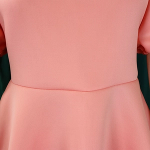 Détail de la couture de taille de la robe rose et de la texture du tricot microporeux