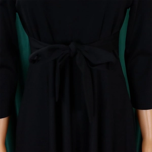 Detailed macro view of the waist tie and bow design on this elegant black maxi dress